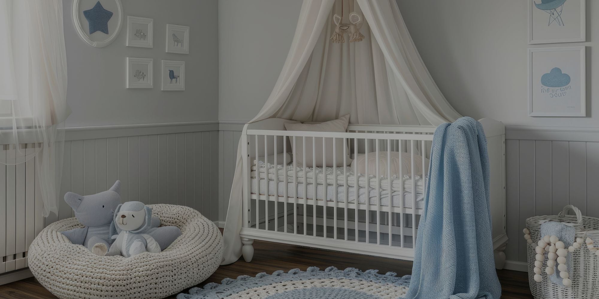 A styled baby nursery featuring a white wooden canopy crib with a cream fabric canopy, a light blue throw blanket, a white knit beanbag chair with plush toys, and a blue patterned rug on a wood floor.